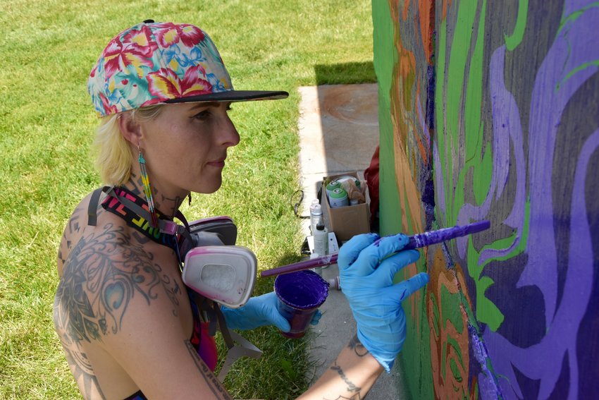Babe Walls painter Grow Love illustrating on her wall flowers that will turn into a rainbow.